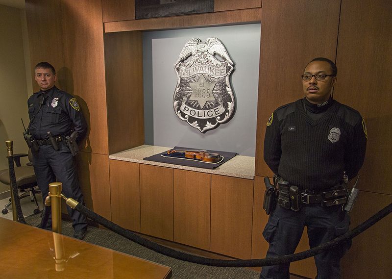 Milwaukee police with the violin. (Tom Lynn/Getty Images)