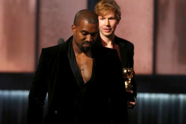 Beck watches Kanye West after Beck won album of the year for "Morning Phase," at the 57th annual Grammy Awards in Los Angeles