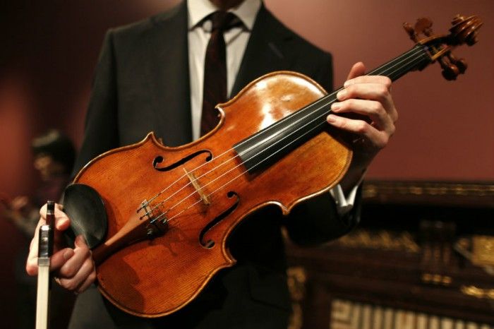 A musician playing a violin, their eyes closed in concentration, lost in the music