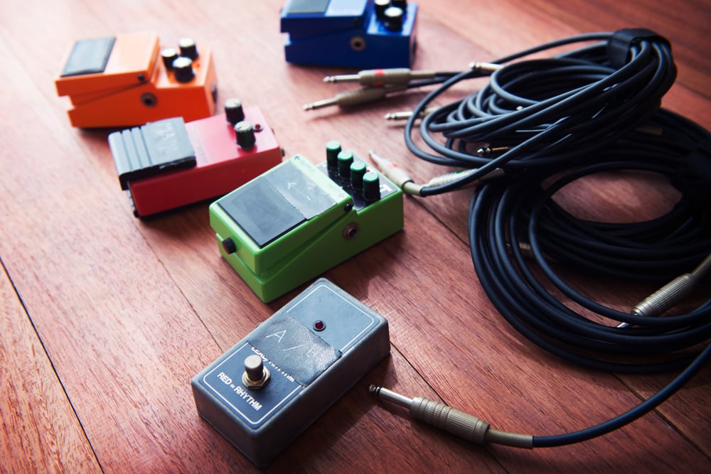 Guitar effect pedals on the floor with cable