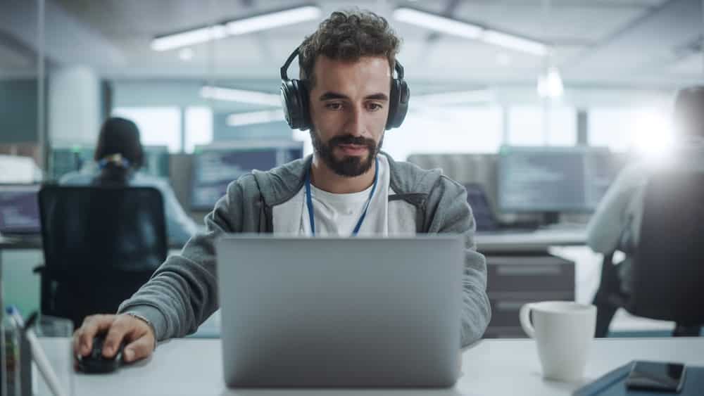 man wearing headphone while using laptop