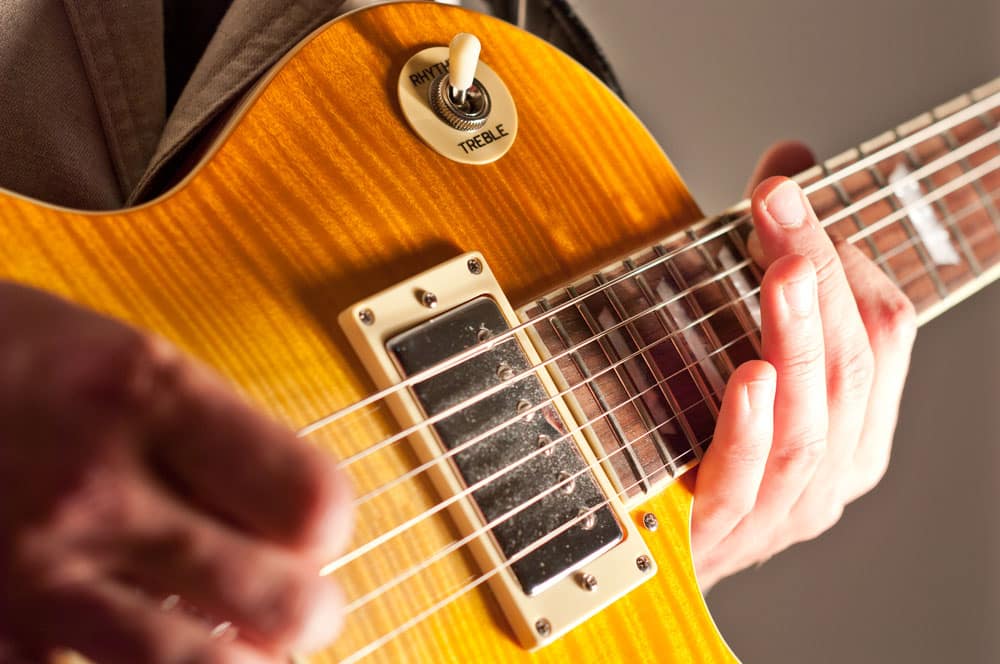 Close up of guitar with hand