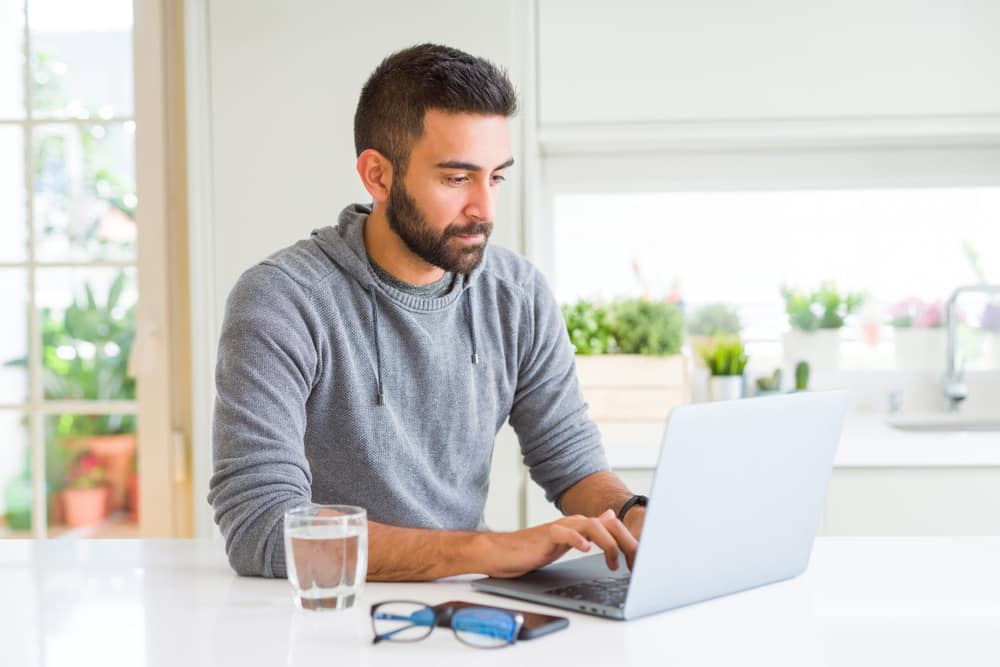 Man smiling working using computer laptop