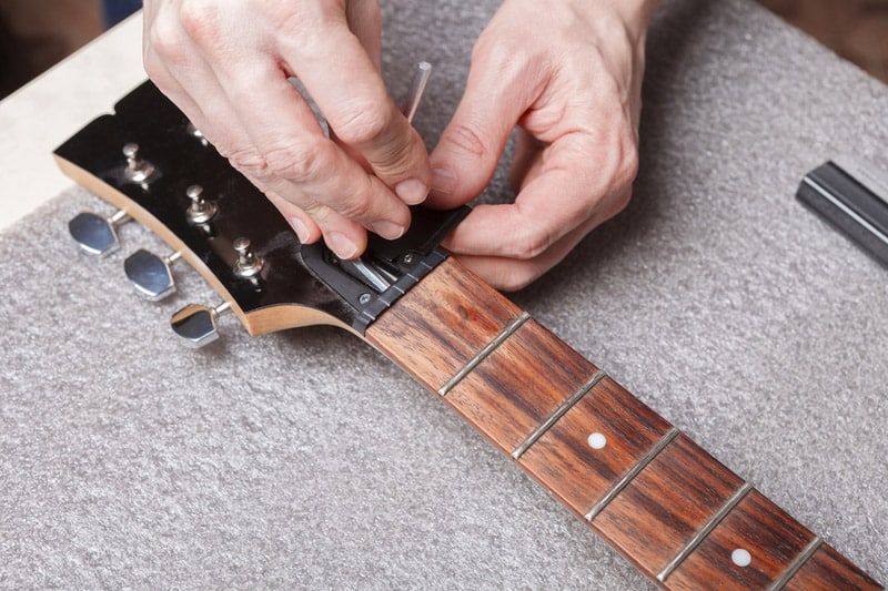 master sets up guitar neck anchor