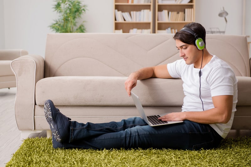 The young man listening to the music from laptop