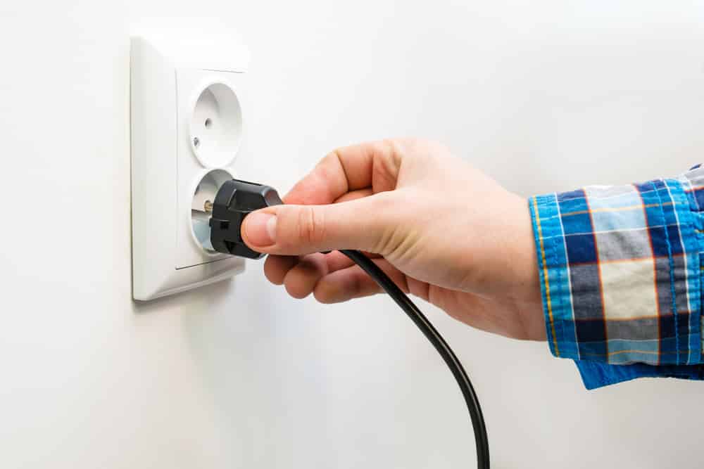 Male hand puts plug in the socket