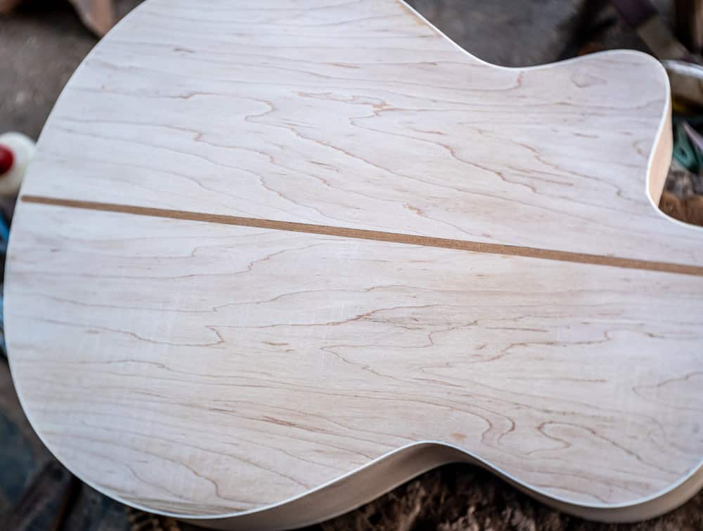 the process of making a handmade wooden guitar made of maple 