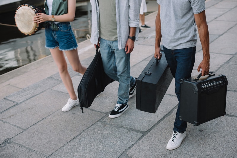 Cropped view of street musicians walking and carrying