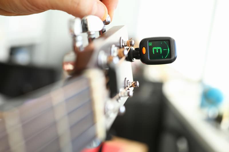 Tuner is installed on guitar neck for tuning notes