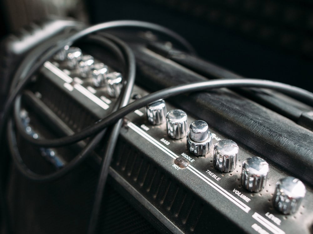 Electric guitar amplifier with silver knobs and cable