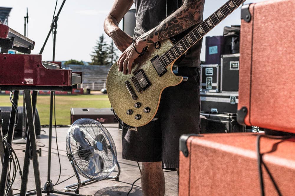 Gold-colored electric guitar worn by man on live stage