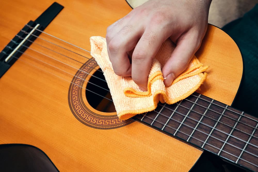 Man cleaning a guitar