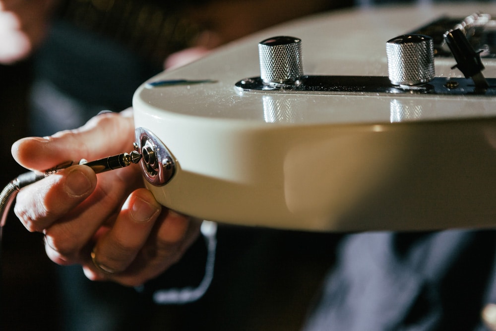 Guitarist connecting guitar in recording studio