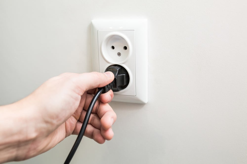 Male hand puts plug in the socket