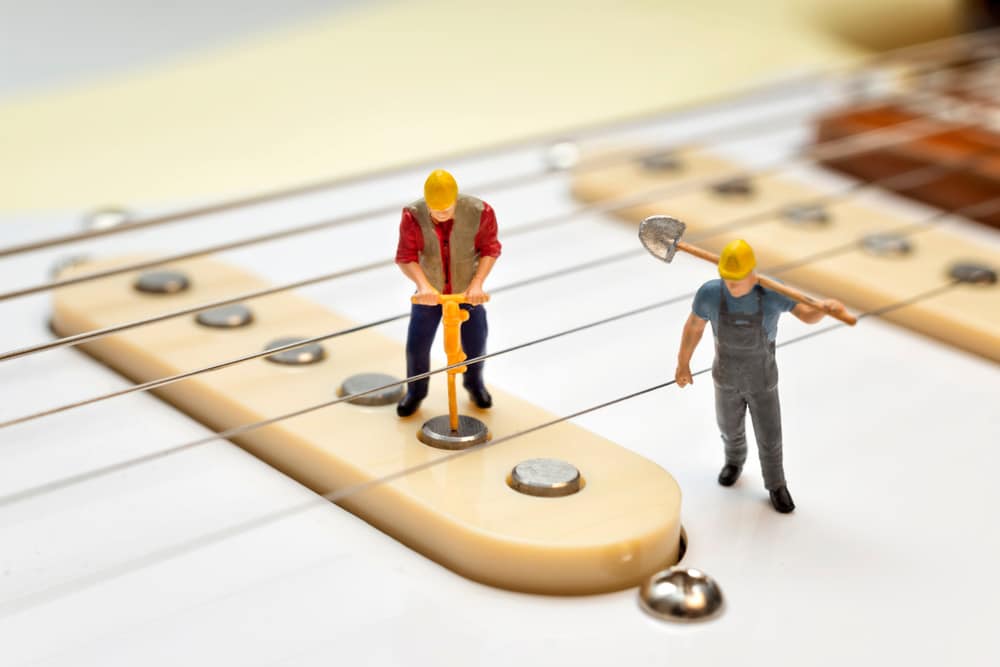 Miniature Workers Fixing The Electric Guitar Pickups
