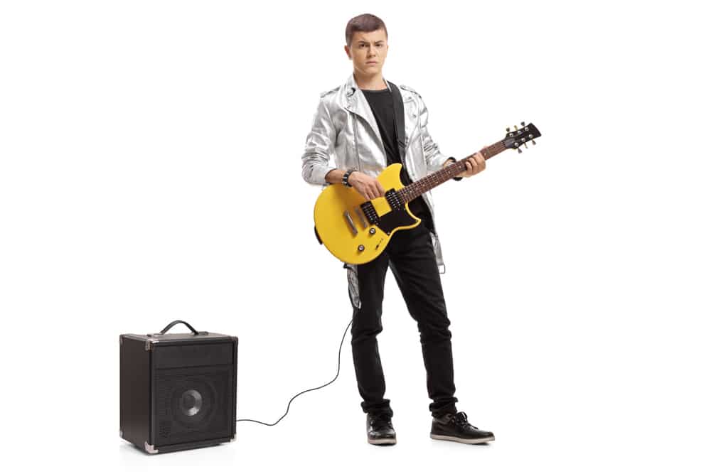 Teenager with an electric guitar and an amplifier